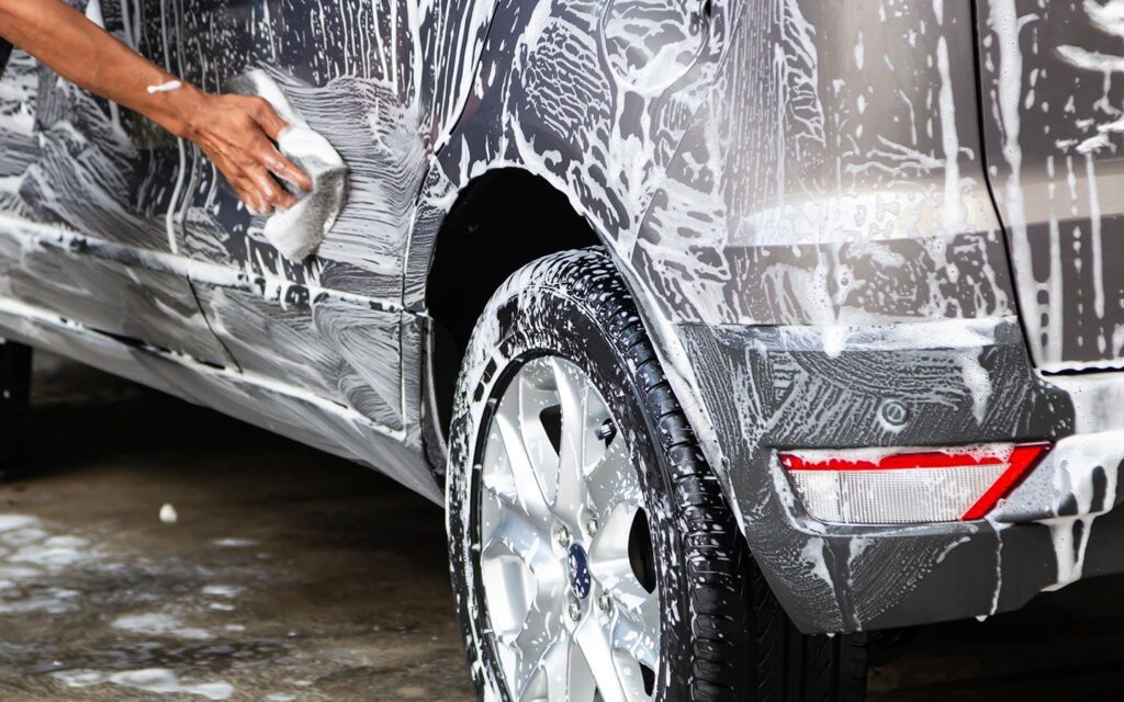 شخص ينظف سيارة ويغسلها